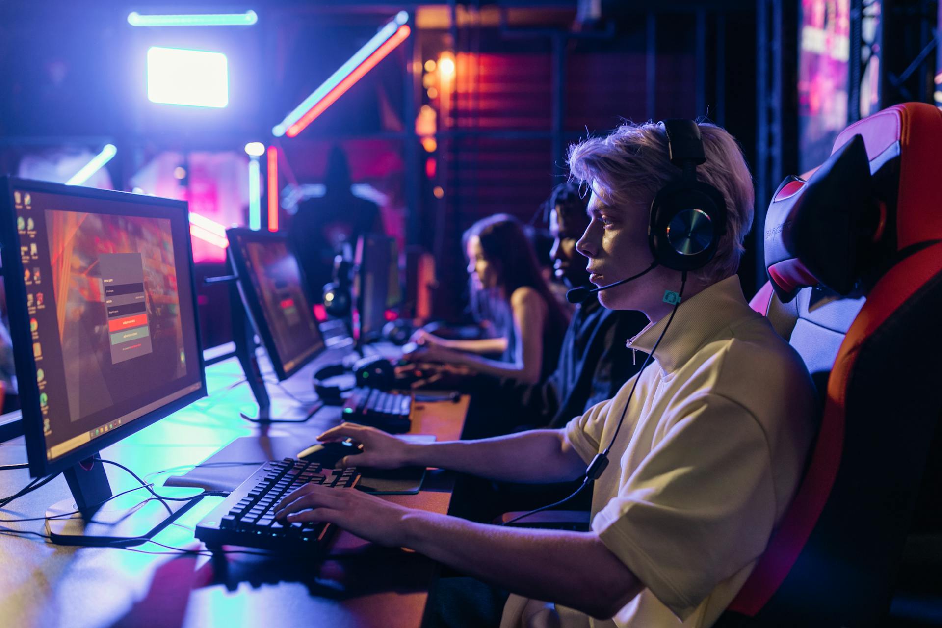 person wearing headset at gaming computer desk